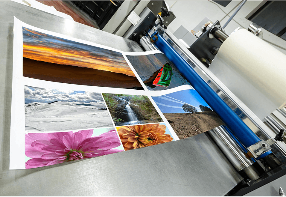 A Printing Solutions machine is printing photos on a sheet of paper.